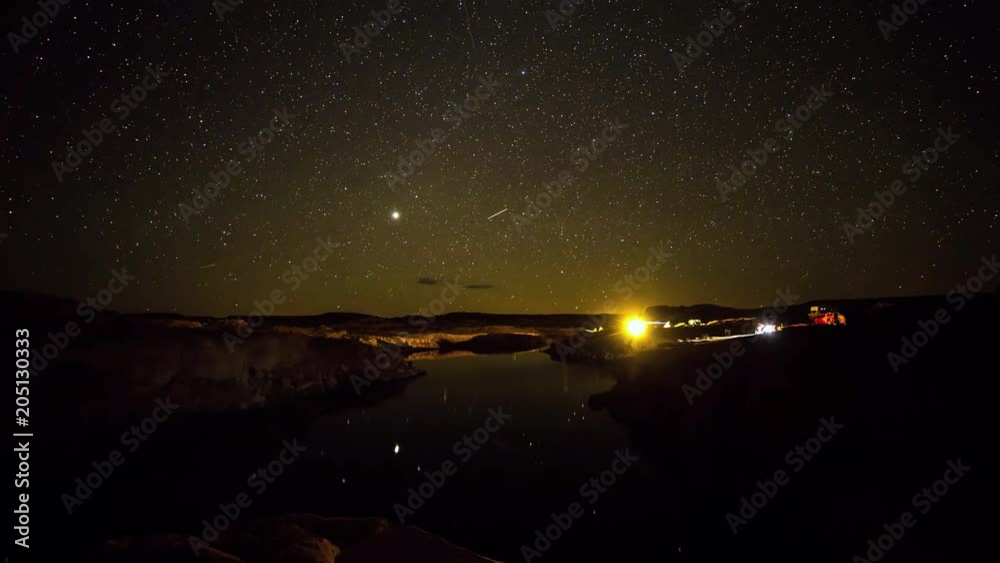 Time lapse of stars over campsites by water at Lake Powell as airplanes move through the sky. Time lapse of stars over campsites by water at Lake Powell as airplanes move through the sky.