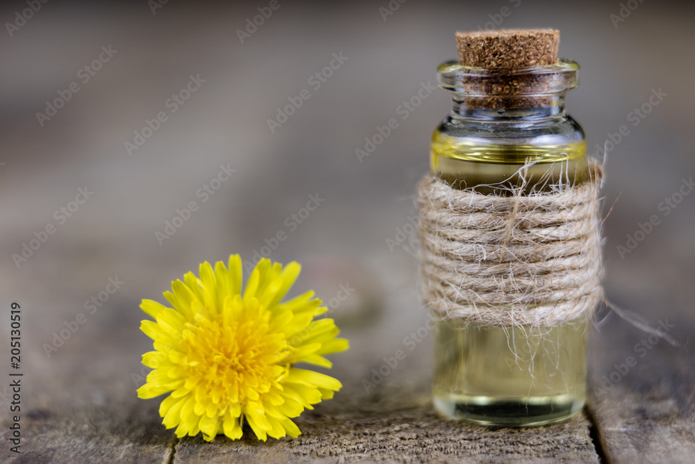 Syrup with dandelion on a wooden table. Cure for colds from natural ingredients. Syrup with dandelion on a wooden table. Cure for colds from natural ingredients.