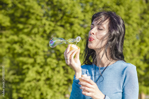 A young woman is having fun  blowing bubbles.