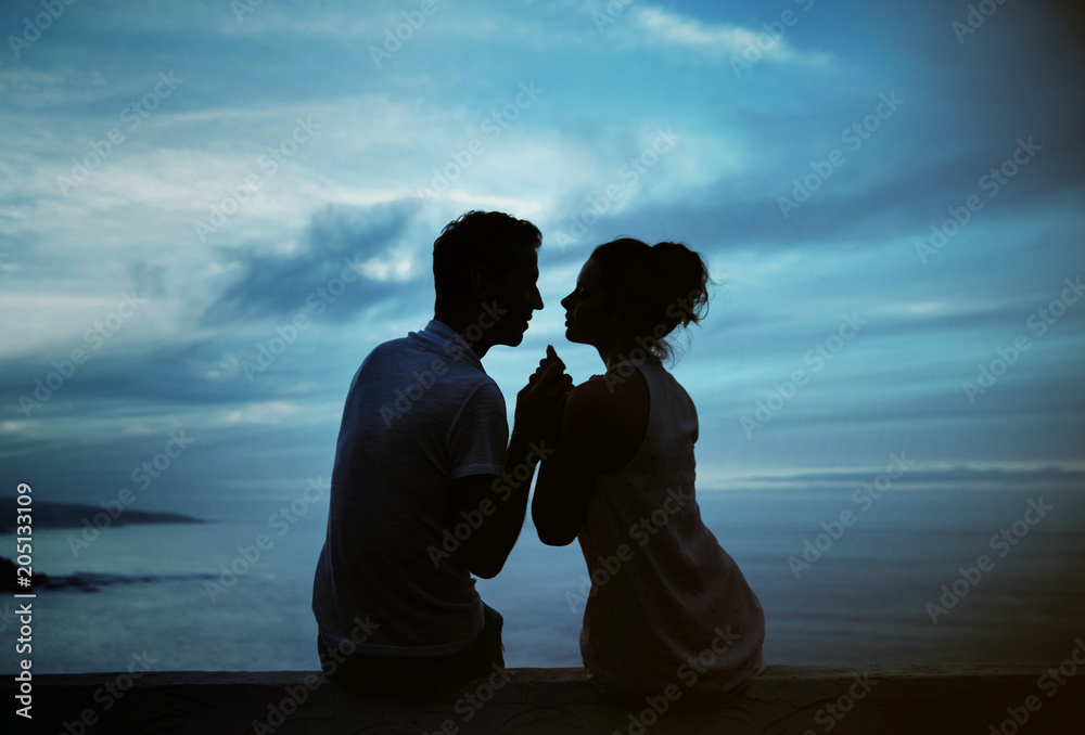 Young couple's silhouette and a storm landscape