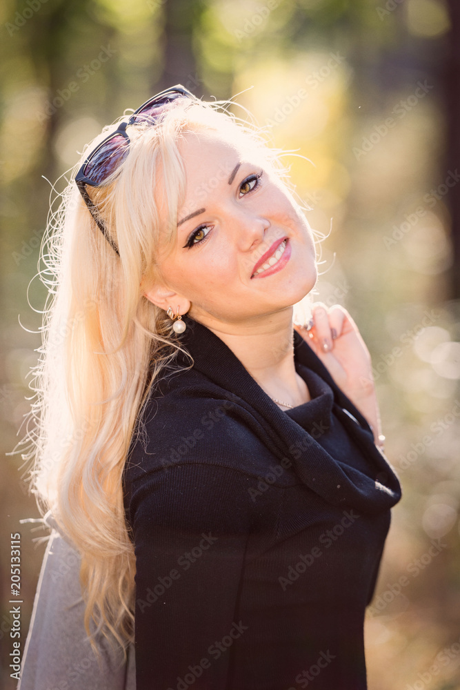 A young, blond and smiling woman portrait on a sunny autumn day. A young, blond and smiling woman portrait on a sunny autumn day.