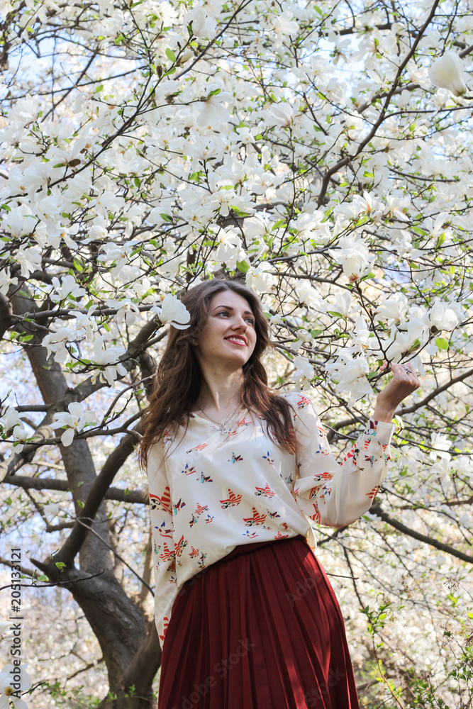Young  girl in beautiful  magnolias tree garden