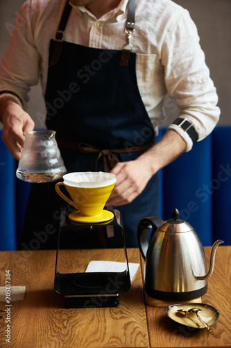 Bartender Hand drip coffee , Barista pouring water on coffee ground with paper filter