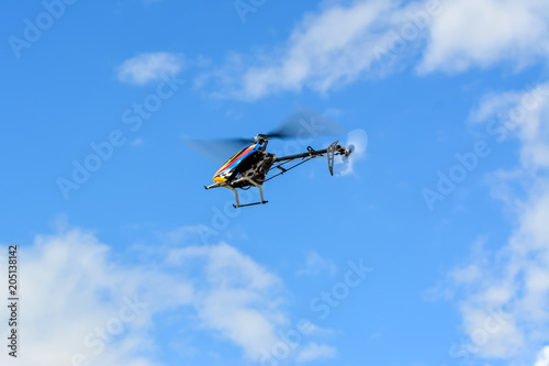 Homemade radio control helicopter on blue sky.