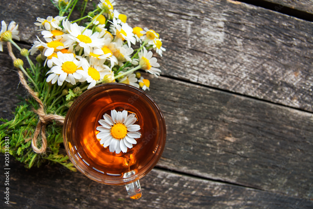 cup of herbal chamomile tea with fresh daisy flowers on wooden ...