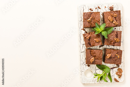 Wallpaper Mural Brownie sweet chocolate dessert with walnuts and meant leaves on retro board with copy space on pastel beige background. Torontodigital.ca