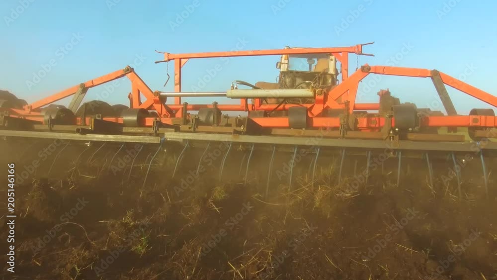 Farmer in tractor soil plows Russia steadicam motion agriculture the ground preparing land with seedbed cultivator as part of pre seeding activities in early spring season of agricultural lifestyle Farmer in tractor soil plows Russia steadicam motion agriculture the ground preparing land with seedbed cultivator as part of pre seeding activities in early spring season of agricultural lifestyle