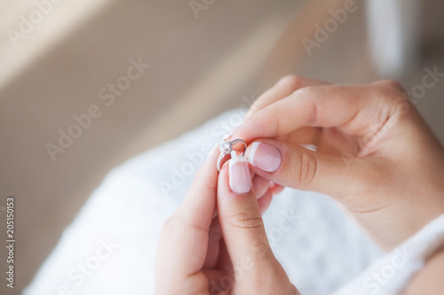 Obraz na płótnie Bride is holding a wedding ring. Beautiful French manicure