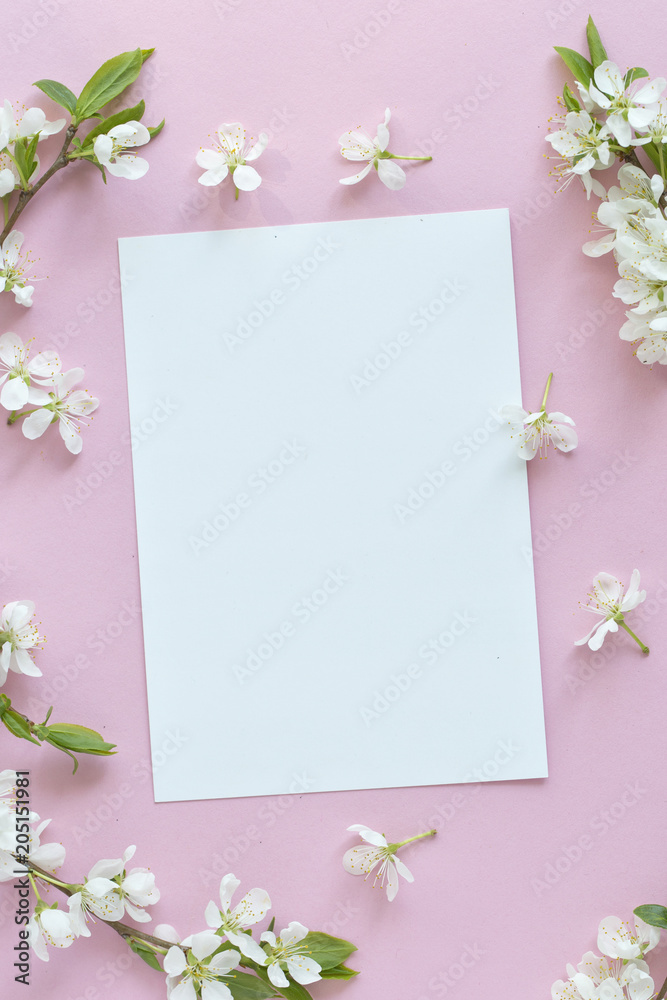 Spring concept. Flat-lay of blossom and card over light pink background, top view with space for your text