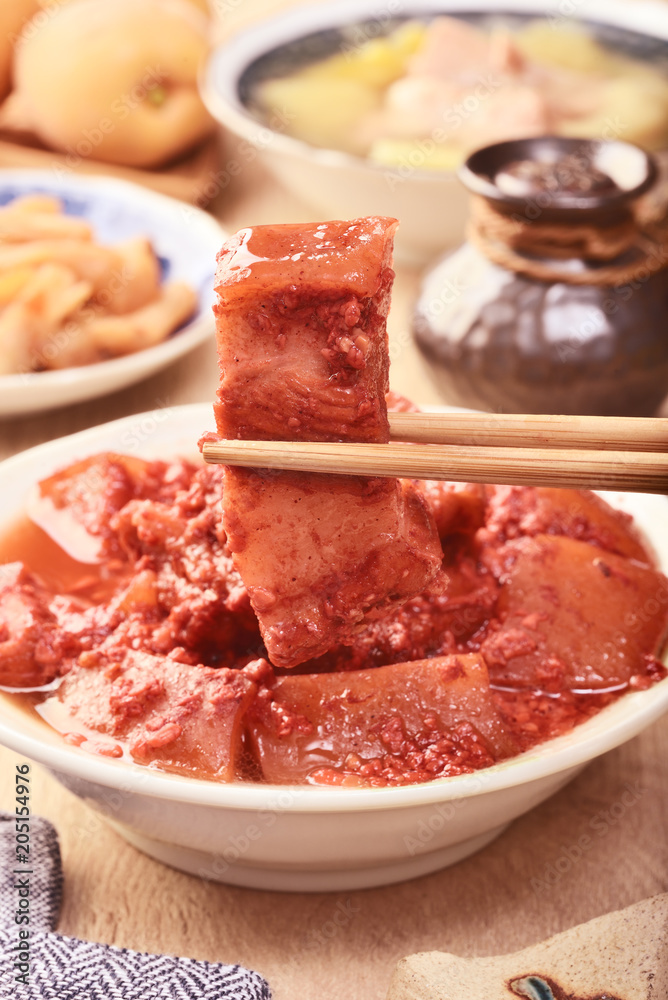 Braised pork with red yeast on the wooden table  
