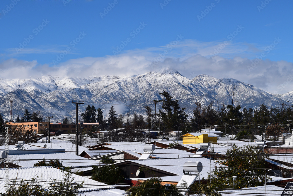 Houses with Andes mountain range snowfall background