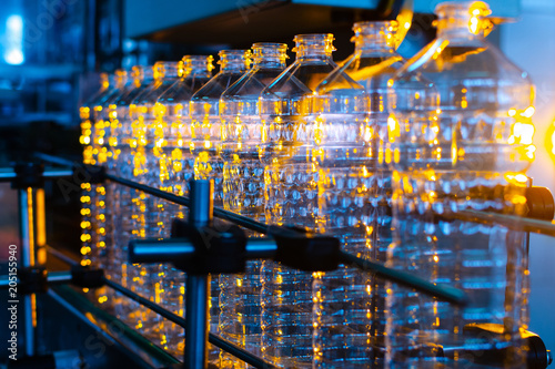 Bottle. Industrial production of plastic pet bottles. Factory line for manufacturing polyethylene bottles. Transparent food packaging.
