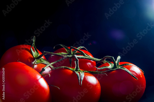 fresh red tomatoes close up black background