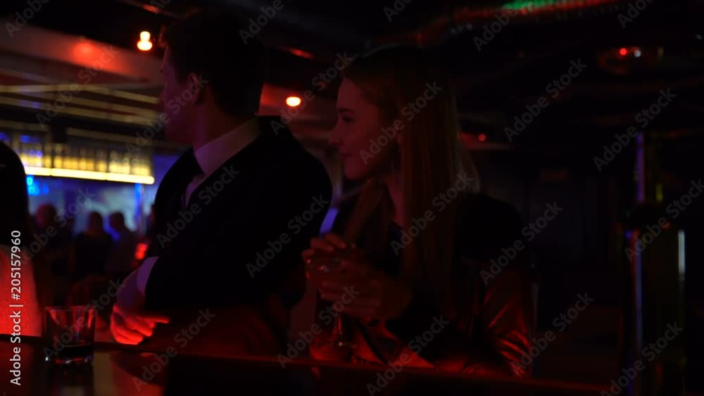 Man and woman spontaneously getting acquainted in bar, drinking and dancing Man and woman spontaneously getting acquainted in bar, drinking and dancing
