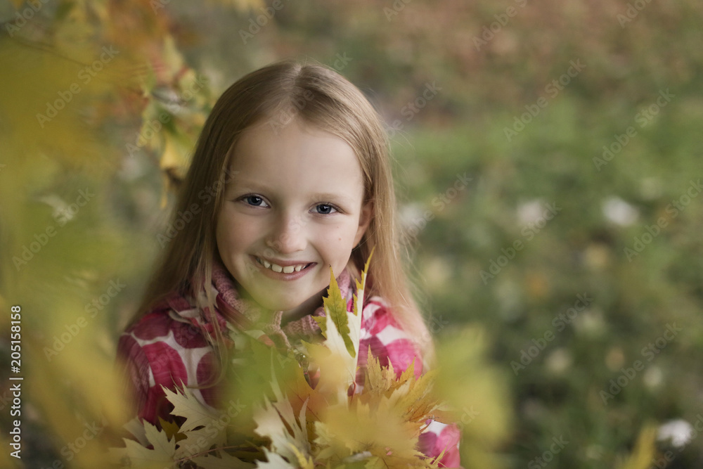 Portrait of a Happy smiling little girl looking at the camera in the autumn park. Cute four years old child enjoying nature outdoors. Portrait of a Happy smiling little girl looking at the camera in the autumn park. Cute four years old child enjoying nature outdoors.