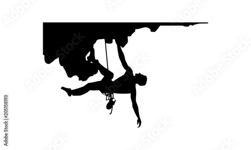 a silhouette picture of a man climbing a rock at an altitude with a rope