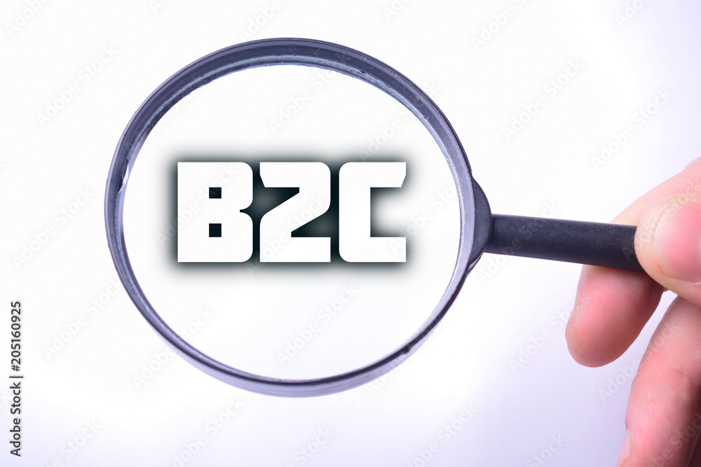 Businessman looking at a magnifying glass word:B2C Businessman looking at a magnifying glass word:B2C