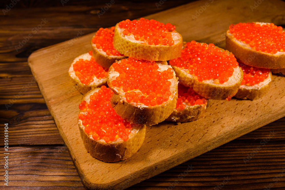 Sandwiches with red caviar on a cutting board Sandwiches with red caviar on a cutting board