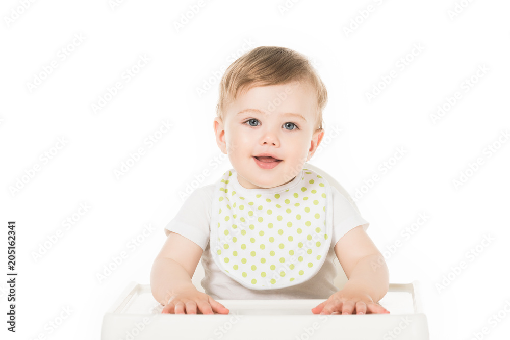 smiling baby boy in bib sitting in highchair isolated on white background smiling baby boy in bib sitting in highchair isolated on white background