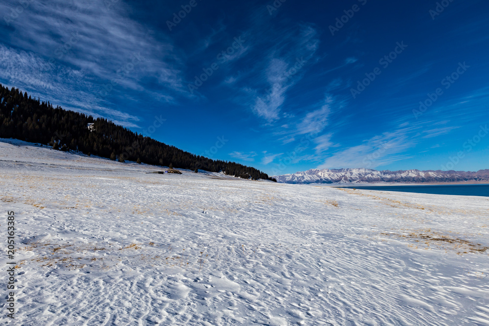 The frozen Sailimu lake with snow mountain background at Yili, Xinjiang of China.