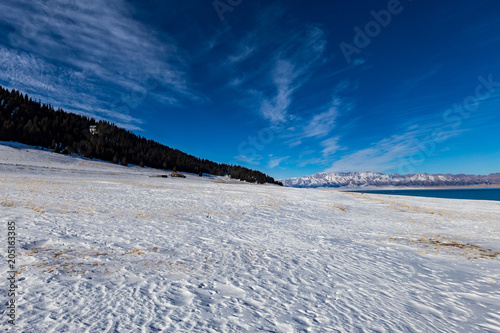The frozen Sailimu lake with snow mountain background at Yili, Xinjiang of China.