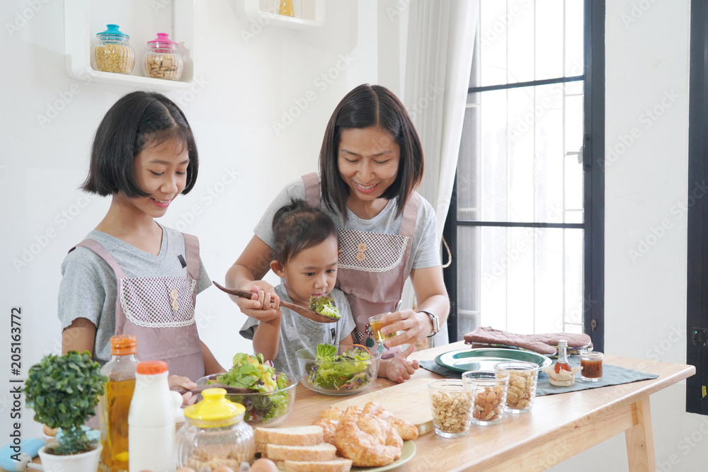 Mother and daughter cooking in the kitchen at home, happy family asian concept