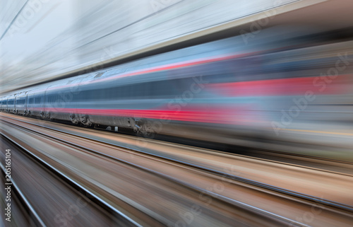 White high speed train runs on rail tracks . Train in motion.