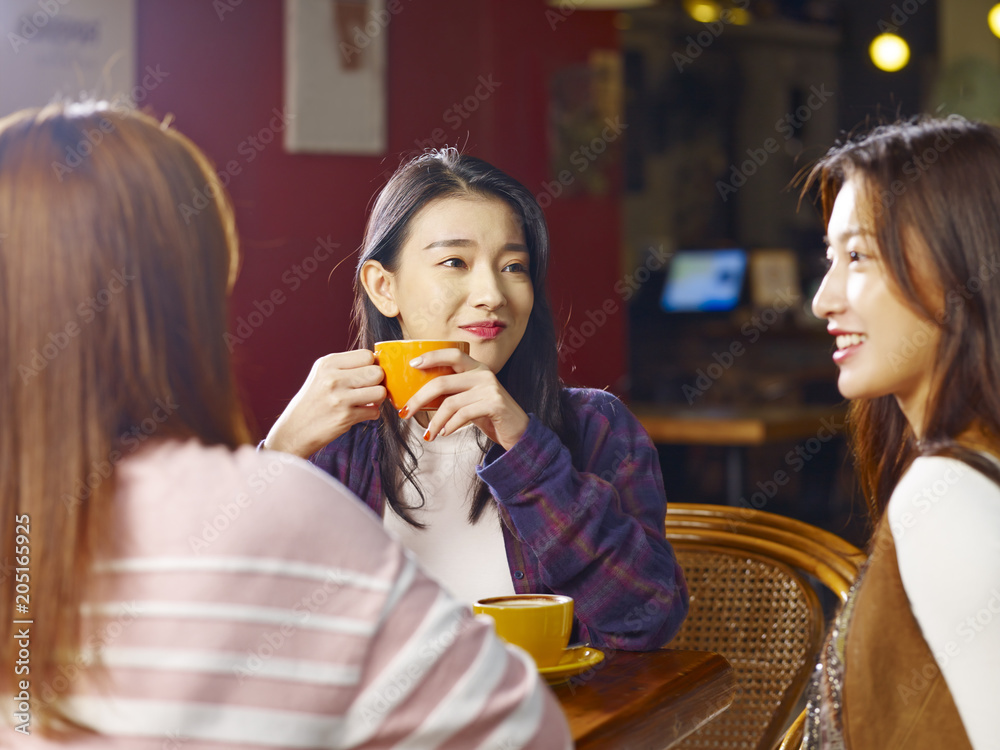 three young asian women chatting talking in coffee shop three young asian women chatting talking in coffee shop