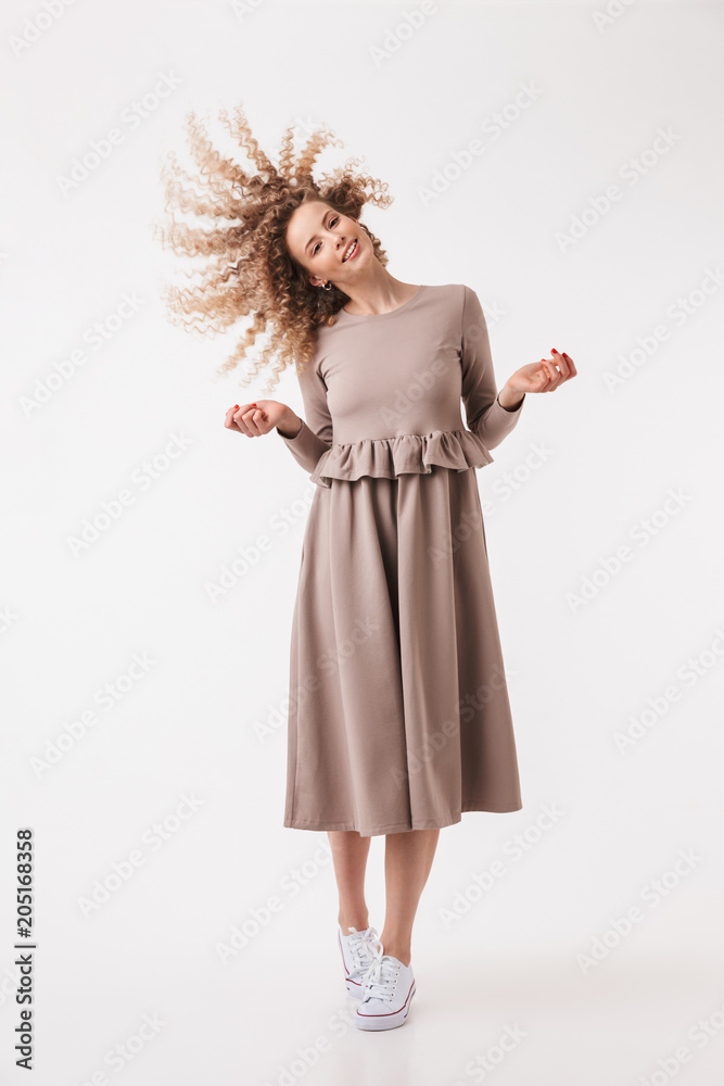 Full length image of Joyful blonde curly woman in dress Full length image of Joyful blonde curly woman in dress