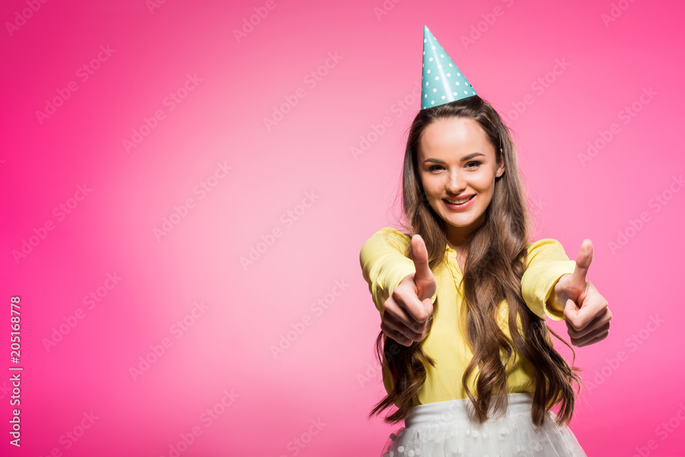 attractive woman with party hat showing thumbs up isolated on pink attractive woman with party hat showing thumbs up isolated on pink