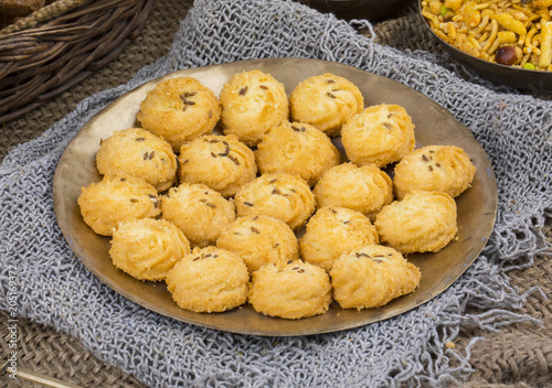 Salted Flavor Small Cumin Cookies or Biscuits Served in Plate Also Know as Nan Khatai or Jeera Cookies is a tea time Snack. Little Sweet and Little Salty on Vintage Background photo