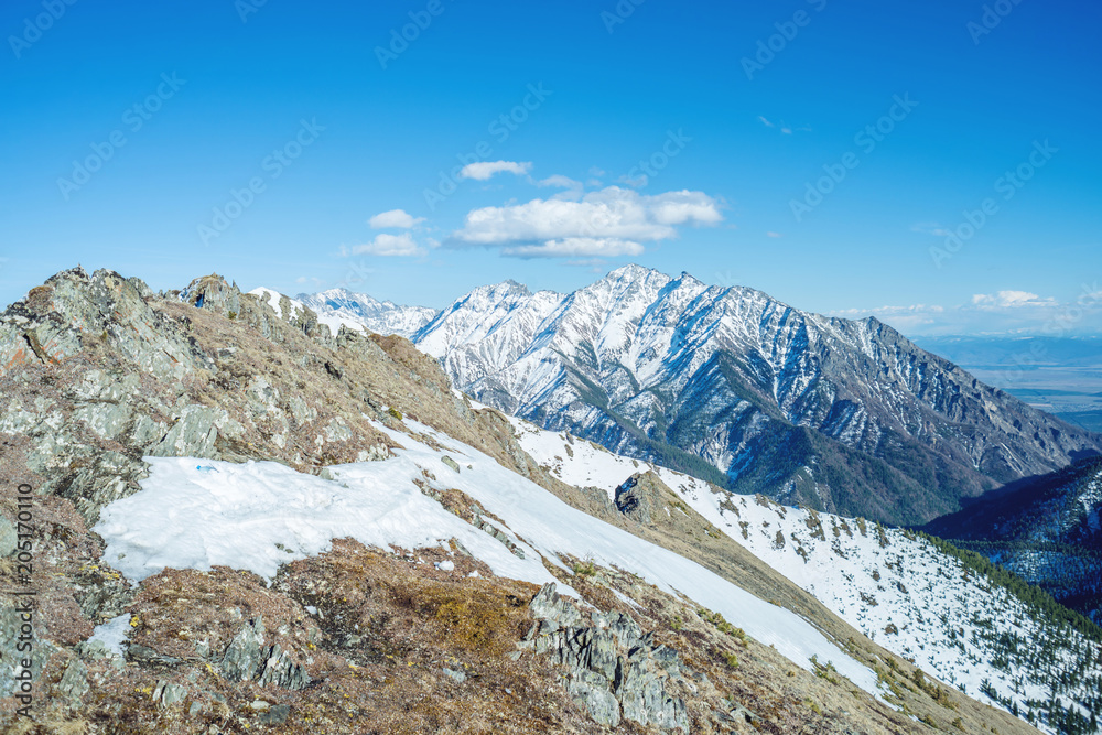 Landscape of snow-capped peaks of the rocky mountains in Sunny weather. Concept of nature and travel