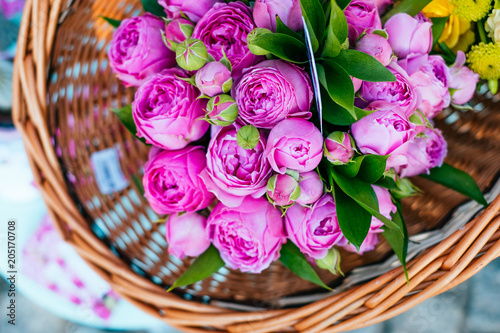 Beautiful magenta roses flower bouquet in the wicker basket. Spotted on the flower market.