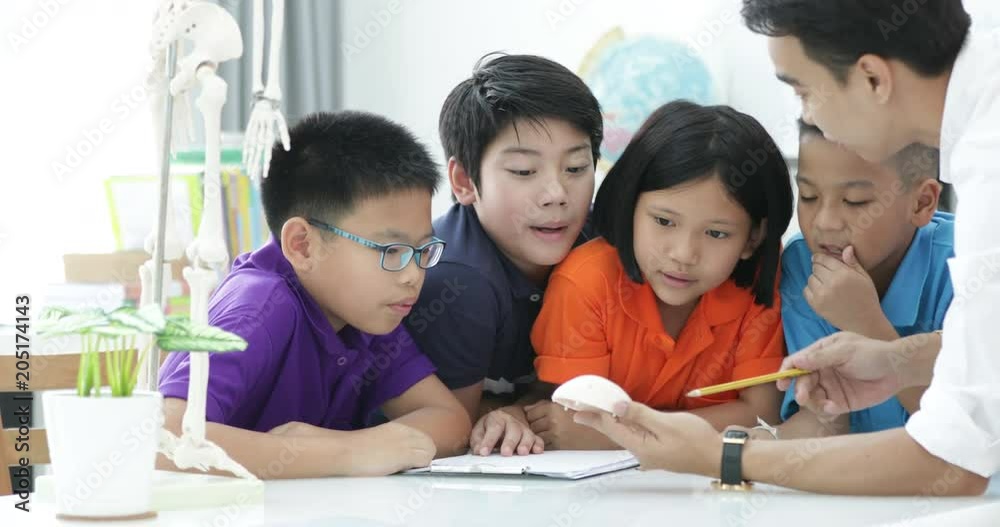 Asian teacher expanding to student in anatomy class with skeleton dummy . Asian teacher expanding to student in anatomy class with skeleton dummy .