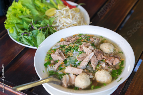 Pho (noodle Soup Laos style) with vegetables with vegetables on background wood table in Pakse, Laos.