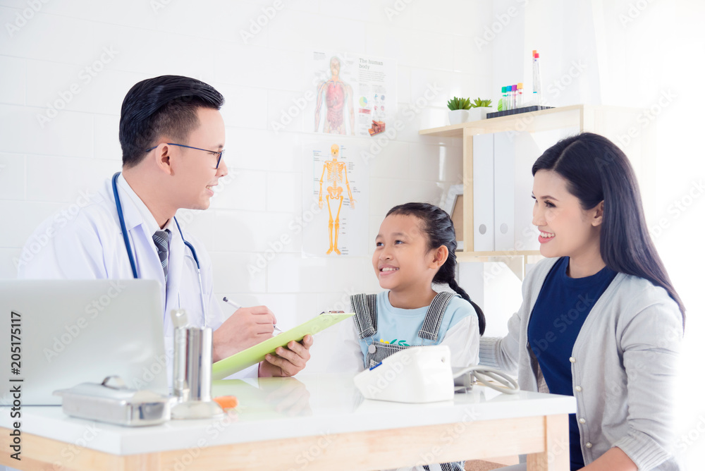 Asian girl and her mother smile while visiting doctor in hospital Asian girl and her mother smile while visiting doctor in hospital