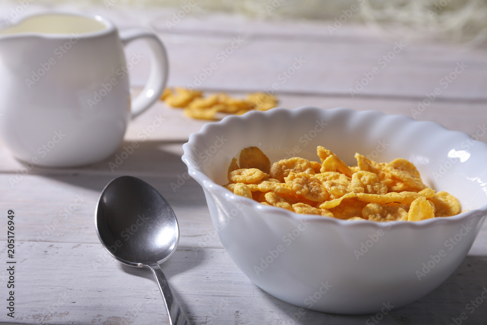 Corn Flakes cereal in a bowl and glass with milk. Morning breakfast. Corn Flakes cereal in a bowl and glass with milk. Morning breakfast.