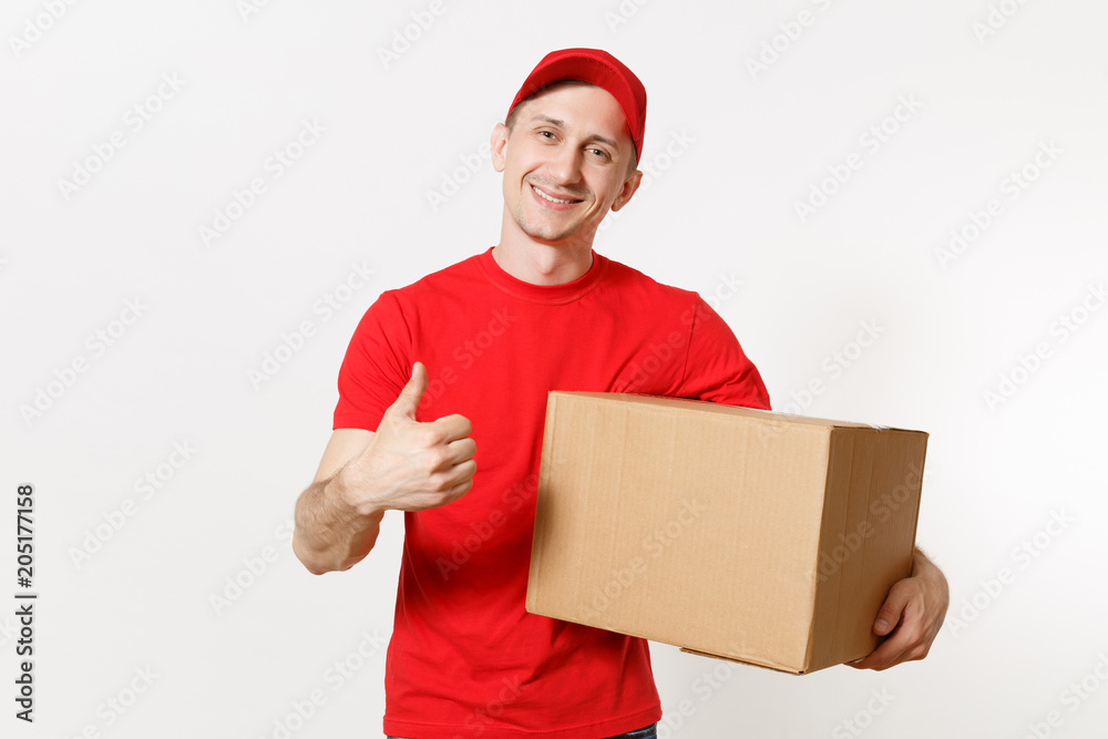 Delivery young man in red uniform isolated on white background. Male in cap, t-shirt, jeans working as courier or dealer holding empty cardboard box. Receiving package. Copy space for advertisement.