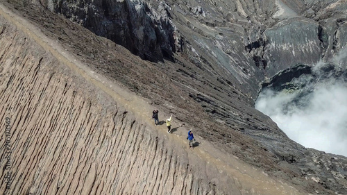 Beautiful adventure mountain ridge walkway on top of active Volcano with smoke Mount Bromo on from Pananjakan Peak at Java island in Indonesia, photo from drone at bird eye view at volcano photo