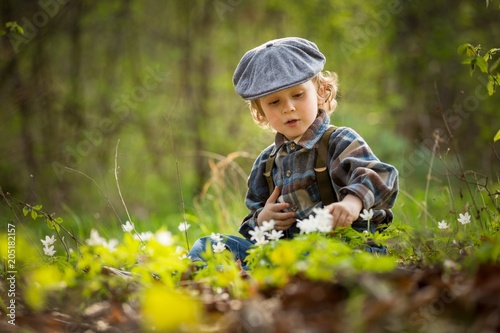 Fotografie Small boy playing in spring forest