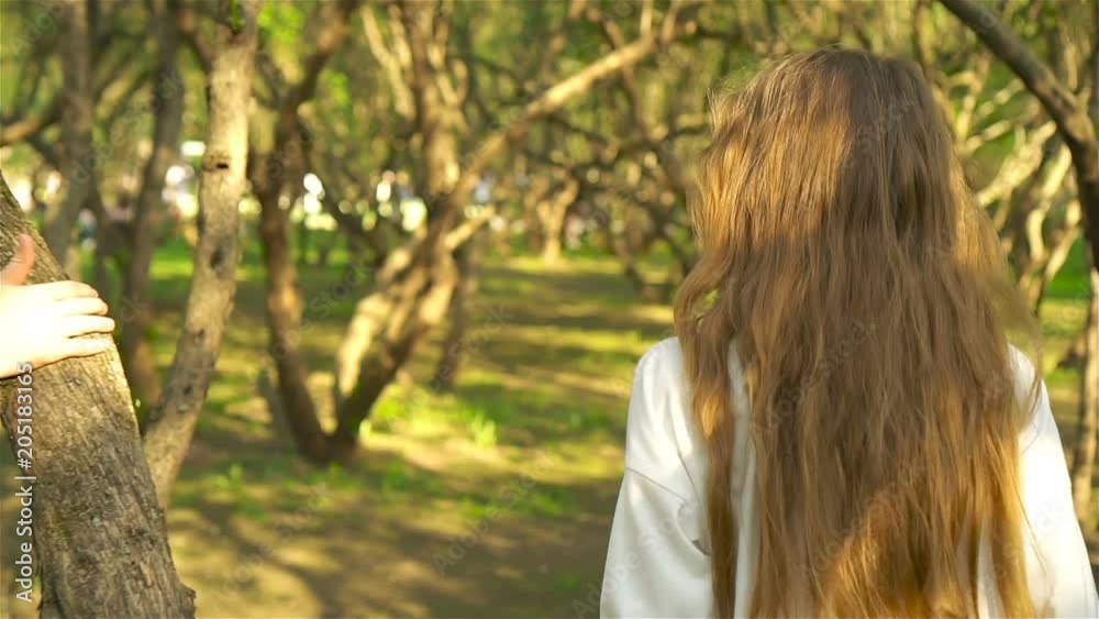 Cute girlы in blooming apple tree garden enjoy the warm day