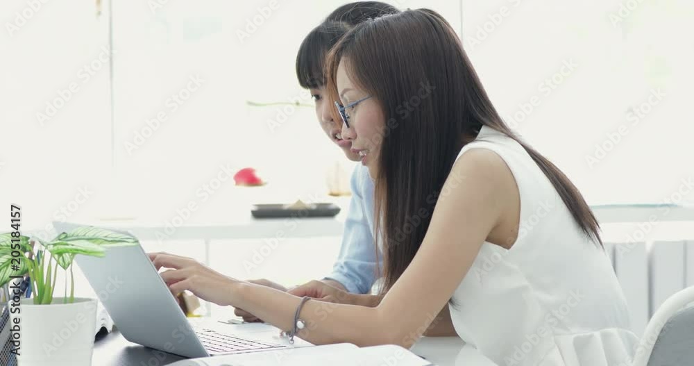 Asian senior worker are teaching new worker .They are work with laptop computer with smile face. Asian senior worker are teaching new worker .They are work with laptop computer with smile face.