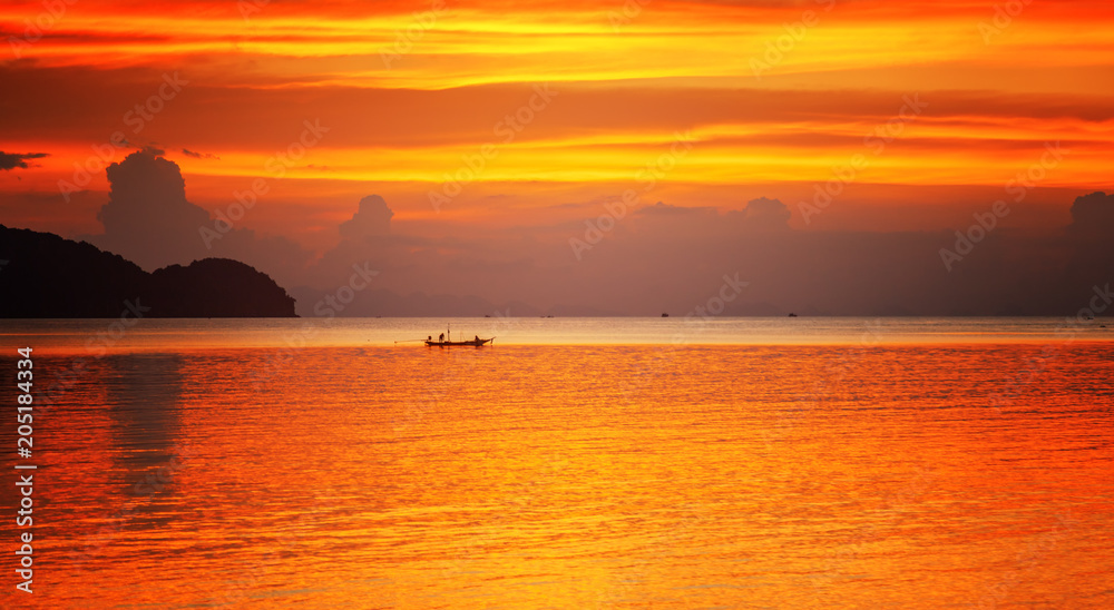 boat in the sea on a background of a colorful colorful stunning sunset on a tropical beach on a paradise island