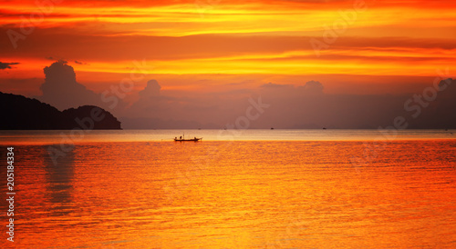 boat in the sea on a background of a colorful colorful stunning sunset on a tropical beach on a paradise island