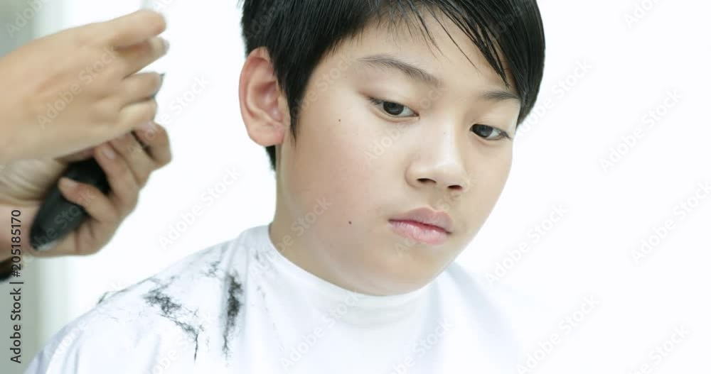 A boy having a haircut with hair clippers
A boy having a haircut with hair clippers