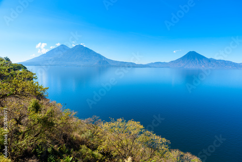 View from Lake Atitlan in the early morning  blue skys and clear water  beautiful magic lake with volcanos and indigenous people in the highland of Guatemala 