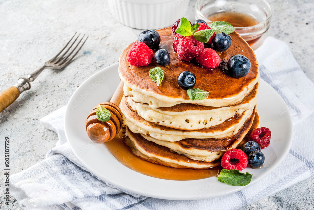 Healthy summer breakfast,homemade classic american pancakes with fresh berry and honey, morning light grey stone background copy space Healthy summer breakfast,homemade classic american pancakes with fresh berry and honey, morning light grey stone background copy space