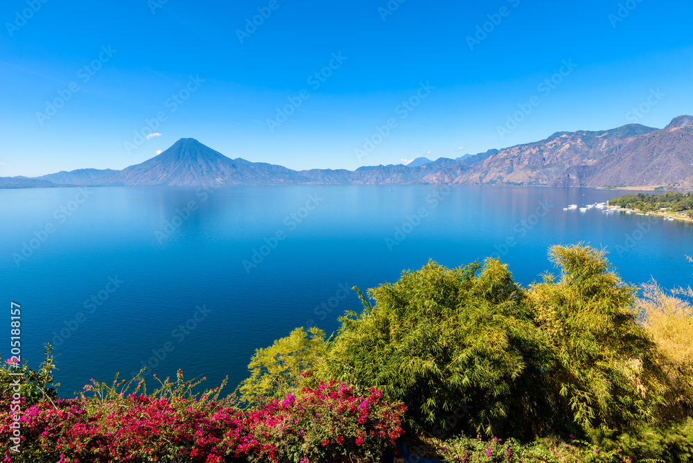View from Lake Atitlan in the early morning, blue skys and clear water, beautiful magic lake with volcanos and indigenous people in the highland of Guatemala 