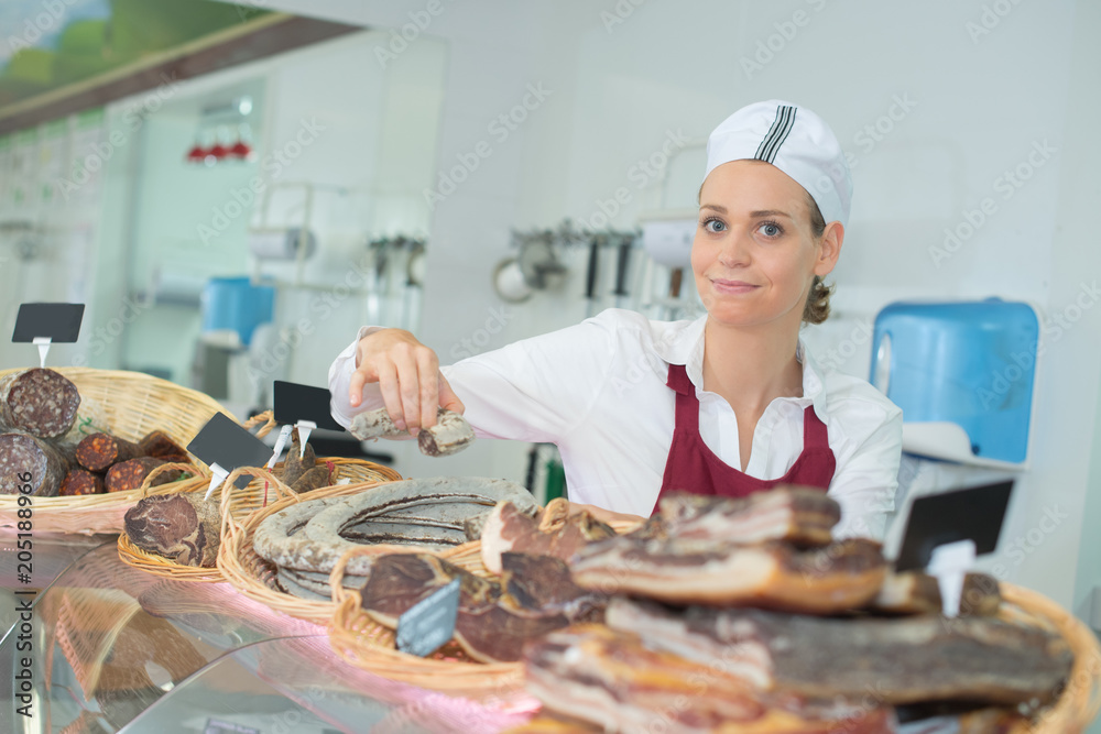 female selling delicious prosciutto meat on market