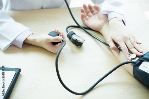 Doctor measuring patient arterial blood pressure. Health care,hospital and medicine concept - doctor and patient measuring blood pressure photo